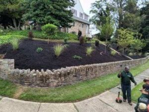 Liberty Landscaping Services Crew installs retaining wall and plants and mulches landscape beds.